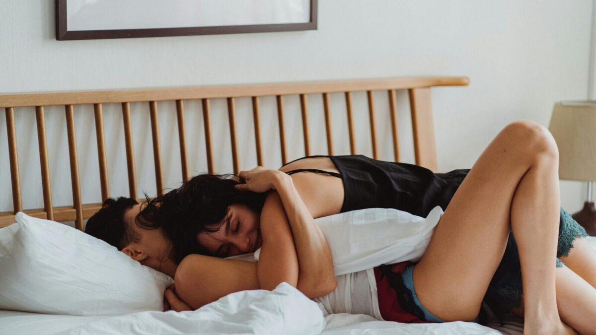 A loving couple embracing on a bed, showcasing warmth and intimacy in a cozy indoor setting.