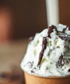 Indulge in a creamy ice cream adorned with rich chocolate drizzle for a decadent treat.