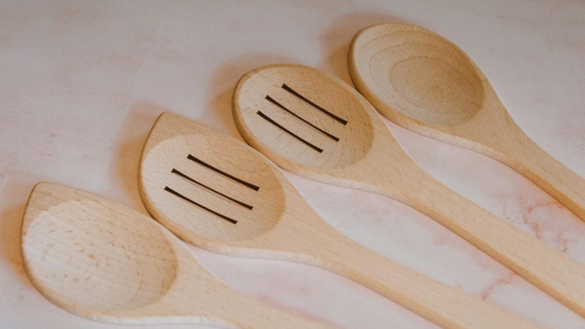 Close-up of wooden cooking spoons and spatulas arranged on a marble countertop. Ideal for kitchen decor.