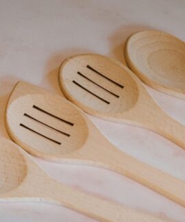 Close-up of wooden cooking spoons and spatulas arranged on a marble countertop. Ideal for kitchen decor.