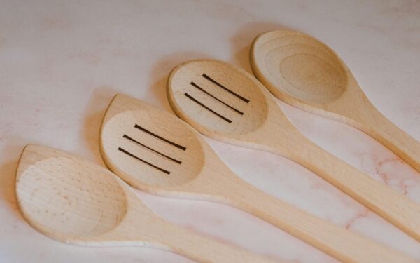 Close-up of wooden cooking spoons and spatulas arranged on a marble countertop. Ideal for kitchen decor.