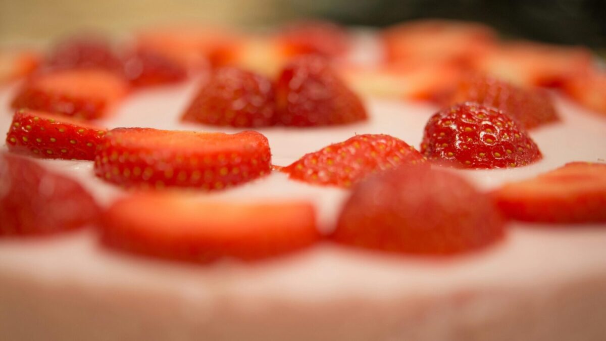 Macro shot of a delicious strawberry topped cream dessert, perfect for a sweet indulgence.