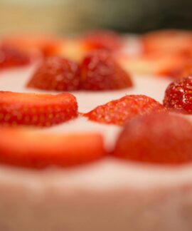 Macro shot of a delicious strawberry topped cream dessert, perfect for a sweet indulgence.