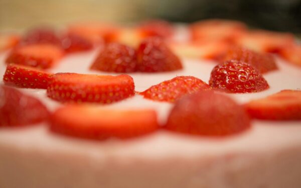 Macro shot of a delicious strawberry topped cream dessert, perfect for a sweet indulgence.