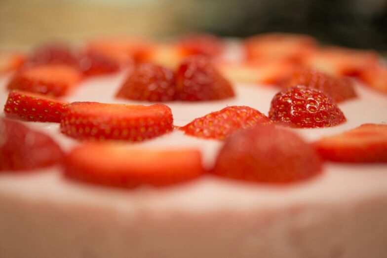 Macro shot of a delicious strawberry topped cream dessert, perfect for a sweet indulgence.