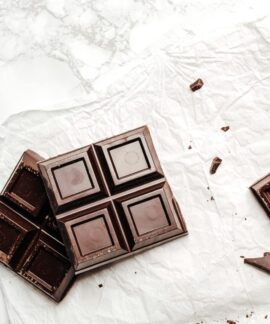 Elegant display of dark chocolate bars on a white marble surface. Perfect for dessert lovers.