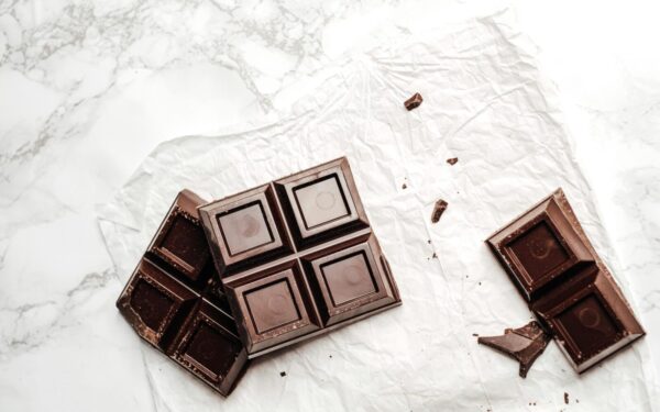 Elegant display of dark chocolate bars on a white marble surface. Perfect for dessert lovers.
