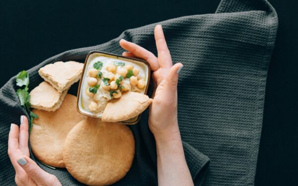 Delicious hummus with chickpeas served with freshly baked pita bread. A healthy Middle Eastern appetizer.