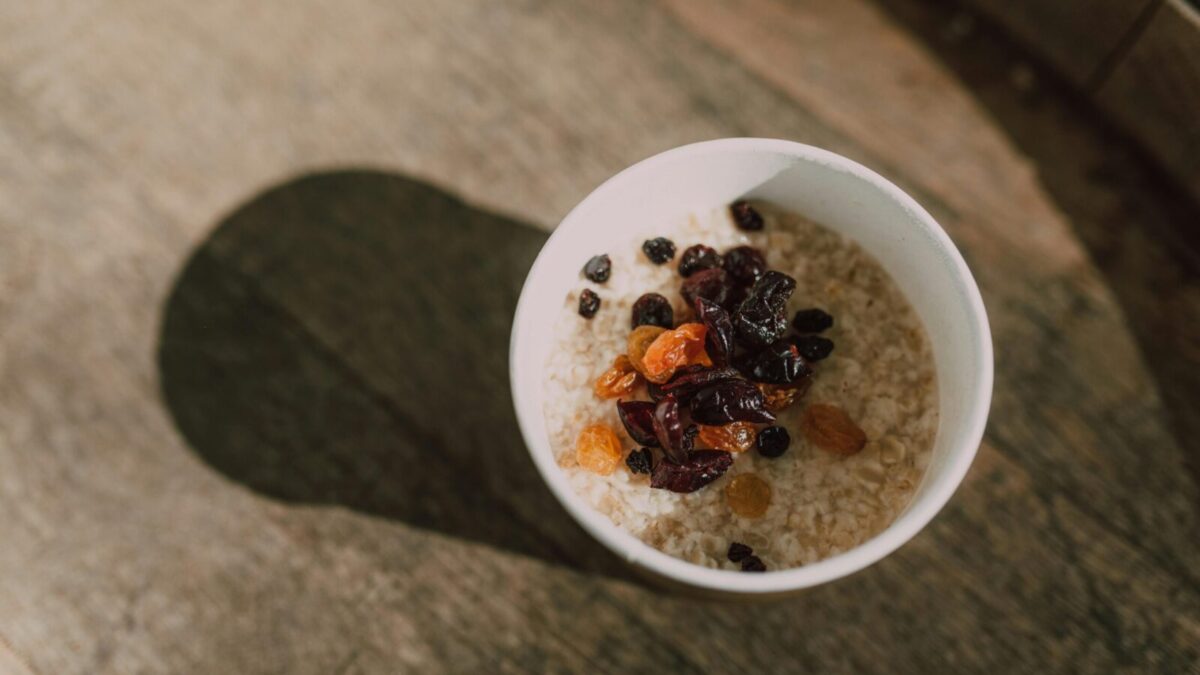 A nutritious bowl of oatmeal topped with a variety of dried fruits photographed from above.