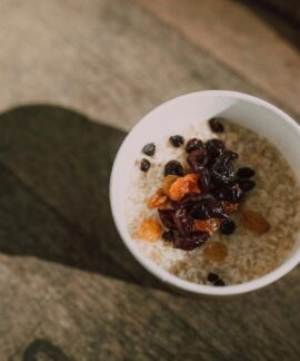 A nutritious bowl of oatmeal topped with a variety of dried fruits photographed from above.