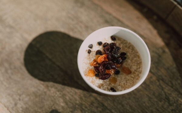 A nutritious bowl of oatmeal topped with a variety of dried fruits photographed from above.