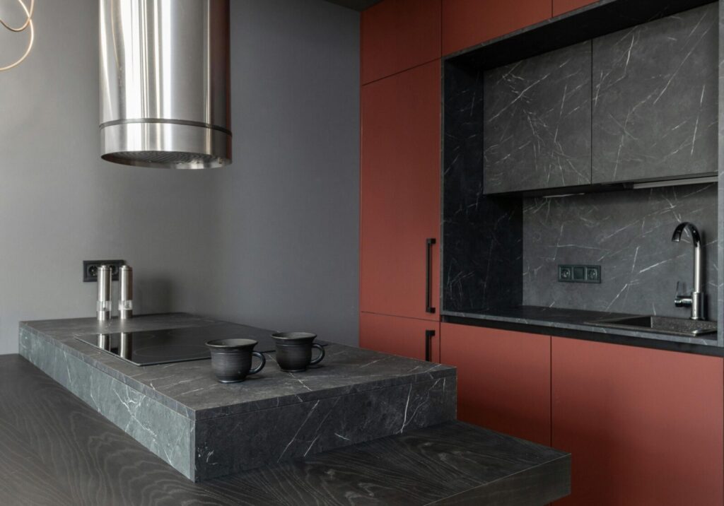 Minimalist style interior design of modern home kitchen with stove built in gray island countertop under range hood and brown cupboards