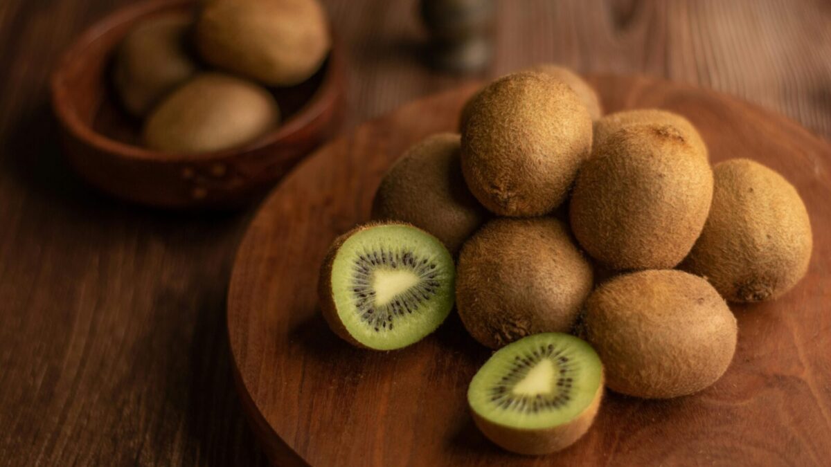 Close-up of organic kiwis on a wooden tray, showcasing the fresh and nutritious fruit.