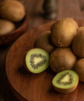 Close-up of organic kiwis on a wooden tray, showcasing the fresh and nutritious fruit.