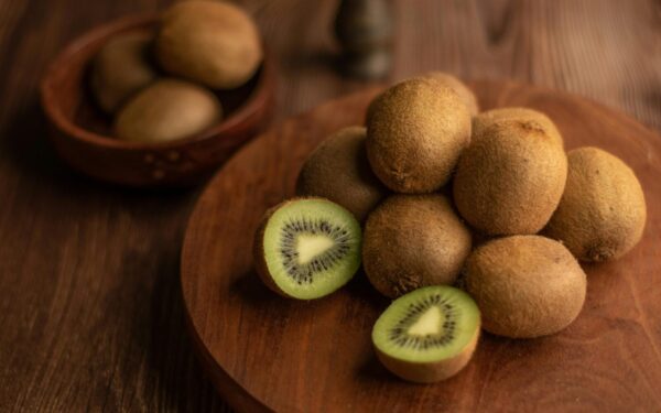 Close-up of organic kiwis on a wooden tray, showcasing the fresh and nutritious fruit.