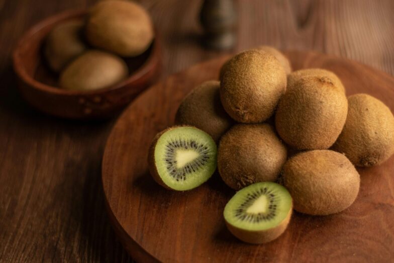 Close-up of organic kiwis on a wooden tray, showcasing the fresh and nutritious fruit.