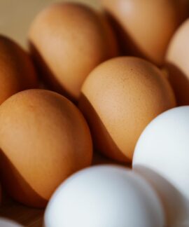 Close-up of brown and white eggs arranged on a surface, showcasing their texture and color.