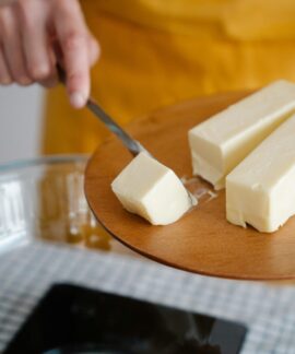 Focused shot of cutting butter for meal preparation, essential cooking ingredient.
