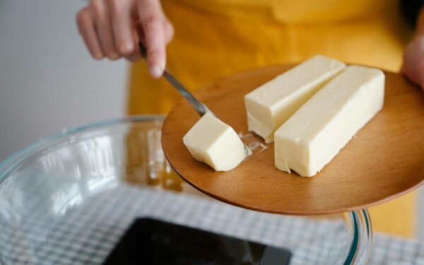 Focused shot of cutting butter for meal preparation, essential cooking ingredient.