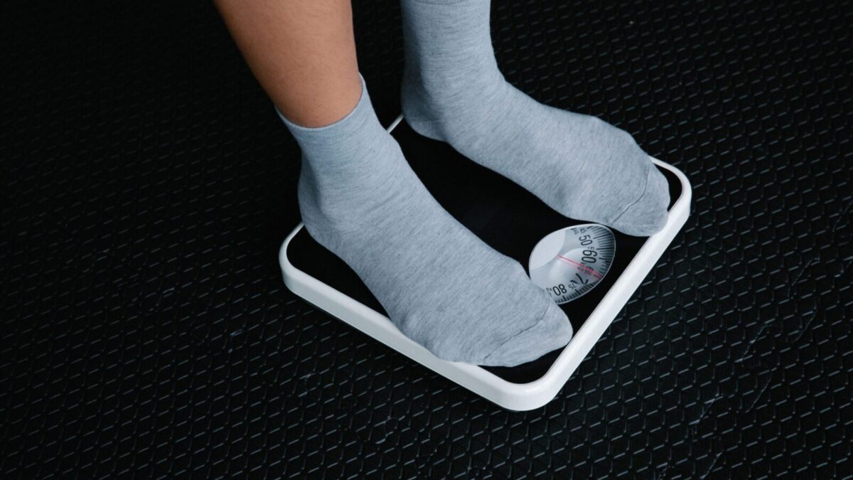 Close-up of feet in socks standing on a scale, focusing on weight measurement.