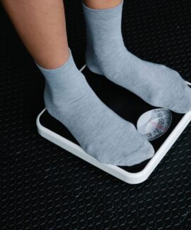 Close-up of feet in socks standing on a scale, focusing on weight measurement.