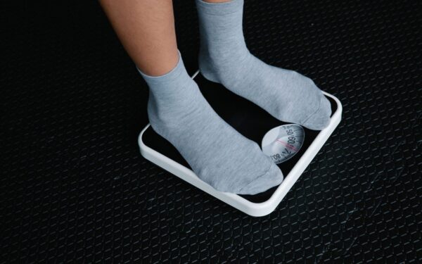 Close-up of feet in socks standing on a scale, focusing on weight measurement.