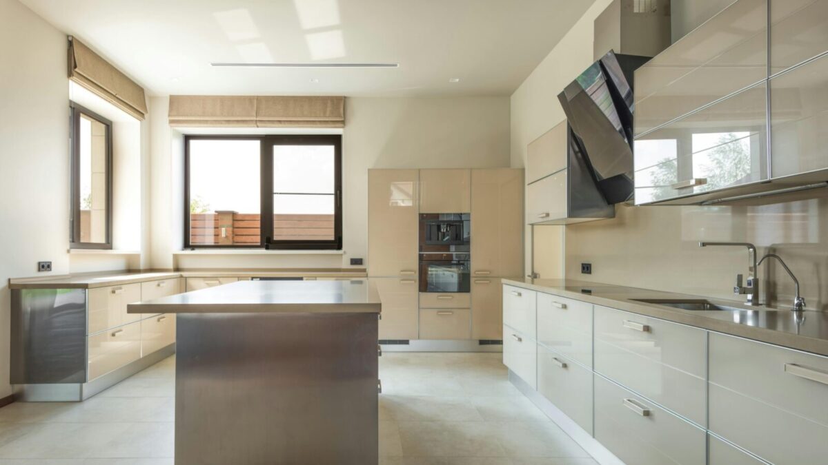 Bright and spacious modern kitchen interior featuring sleek cabinets and a central kitchen island.