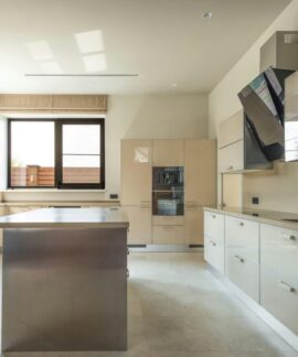 Bright and spacious modern kitchen interior featuring sleek cabinets and a central kitchen island.