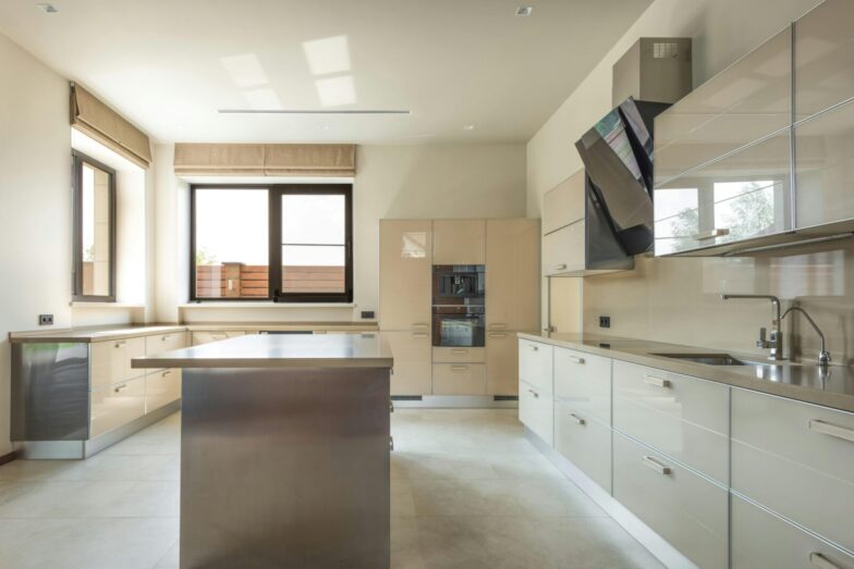 Bright and spacious modern kitchen interior featuring sleek cabinets and a central kitchen island.