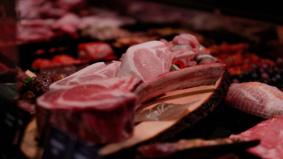 Close-up of a variety of raw meats on display in a market setting, perfect for culinary and food industry themes.