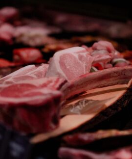 Close-up of a variety of raw meats on display in a market setting, perfect for culinary and food industry themes.