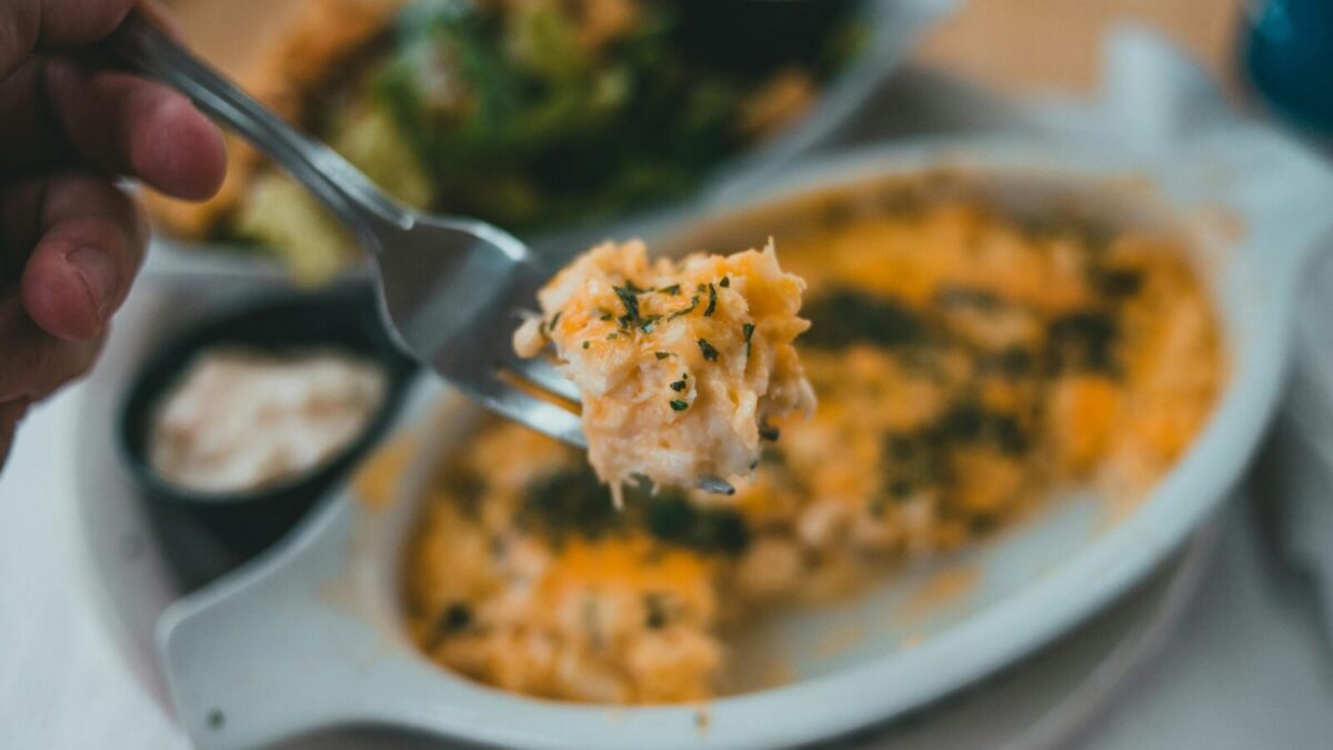 Tasty pasta dish with herbs on fork, close-up, inviting meal.