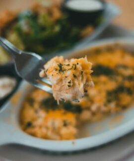 Tasty pasta dish with herbs on fork, close-up, inviting meal.