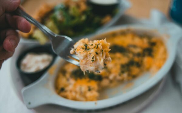 Tasty pasta dish with herbs on fork, close-up, inviting meal.