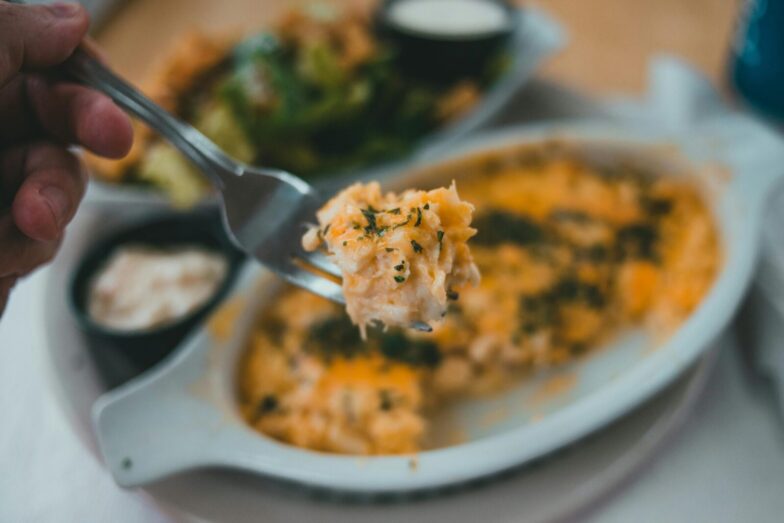 Tasty pasta dish with herbs on fork, close-up, inviting meal.