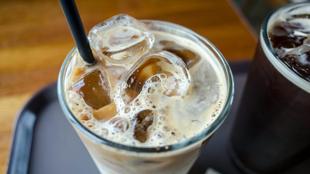 Close-up of a delicious iced milk tea with visible ice cubes and a straw.