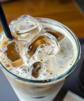 Close-up of a delicious iced milk tea with visible ice cubes and a straw.