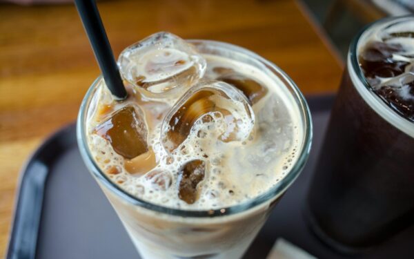 Close-up of a delicious iced milk tea with visible ice cubes and a straw.
