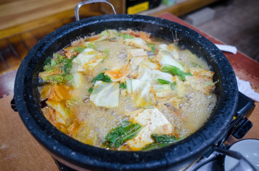 Delicious homemade vegetable soup boiling in a traditional stone pot, capturing rich flavors and vibrant colors.