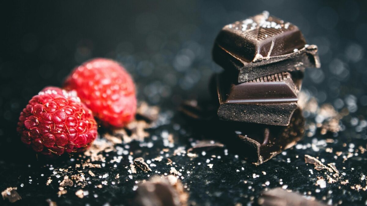 Close-up of dark chocolate pieces and raspberries, perfect for gourmet dessert ideas.
