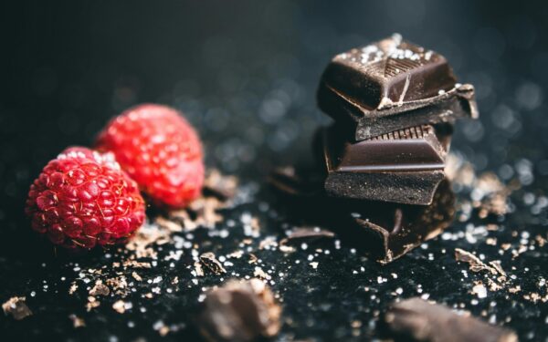 Close-up of dark chocolate pieces and raspberries, perfect for gourmet dessert ideas.