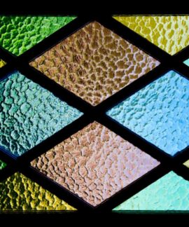 Vibrant stained glass featuring textured geometric patterns and colorful hues.