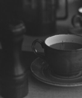 A classic black and white photograph of a coffee table with cups and saucer.
