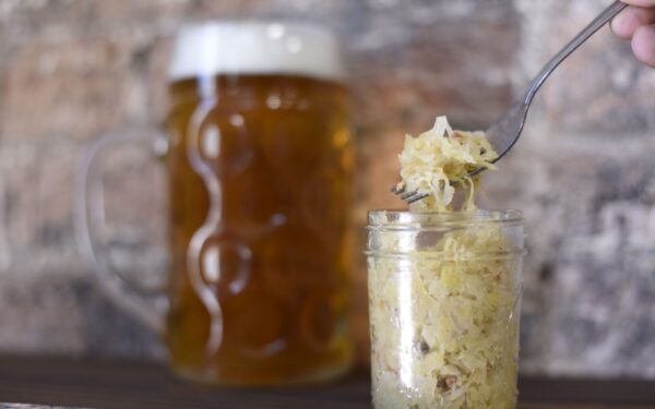A rustic setting featuring a frothy beer mug and sauerkraut in a jar, perfect for pub themes.