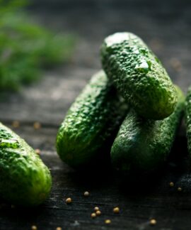 3 green cucumbers on black wooden table