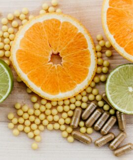 oranges, peas, and limes on a wooden table