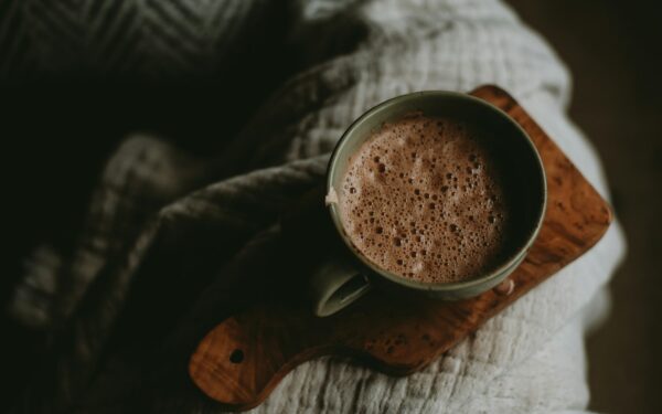 a cup of hot chocolate sitting on top of a wooden board
