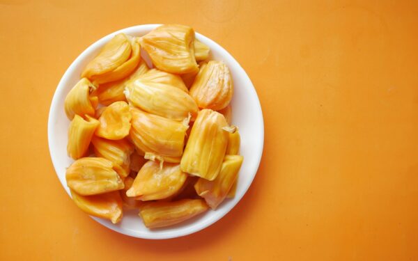 sliced yellow fruit in white ceramic bowl
