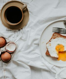 egg on white ceramic plate beside stainless steel fork and knife