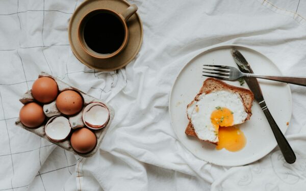 egg on white ceramic plate beside stainless steel fork and knife